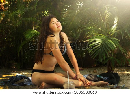 teen girl with long wet brown hair in swimming suit close up portrait on tropical palm jungle background