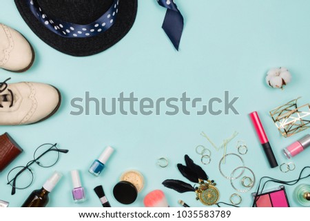 Beautiful flatlay arrangement with various fashion accessories: glasses, cosmetics, jewelry, rings, shoes etc. Mint background. Concept of getting ready to go out. Copyspace