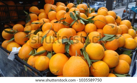 Oranges with green leaves in a street shop