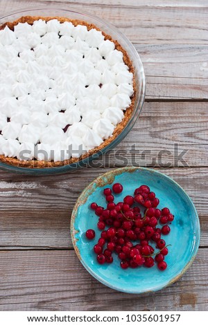 Berry small meringue covered tart wooden table blue ceramics plate.