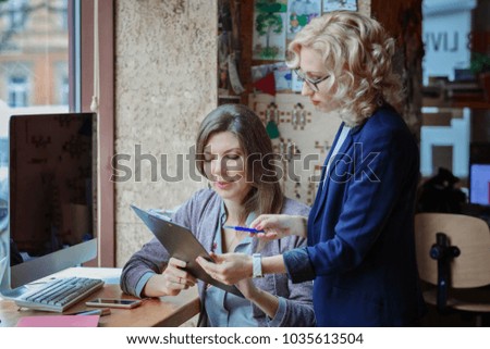 The manager communicates with the client / Two women communicate and one of them signs documents