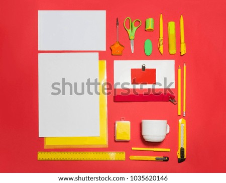 Mock-up business template with cards, papers, pen, pencils, envelope, cup on red background