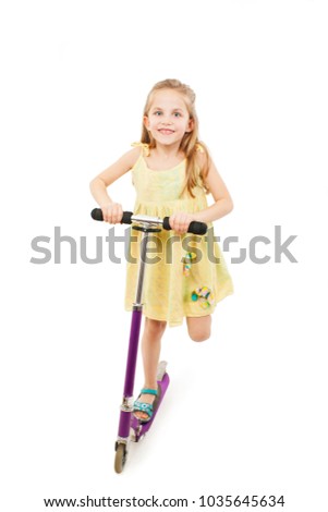 
Adorable little girl using a scooter. Isolated on white background