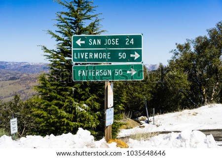 Road directions on top of Mt Hamilton on a rare winter day with snow, San Jose, south San Francisco bay area, California