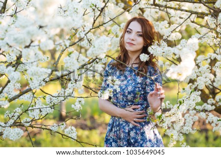 Beautiful dark-haired girl in a blooming spring garden. Lifestyle