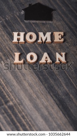 'Home Loan' words with house shape sign on dark wooden table top