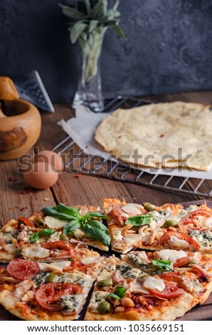 Cut into slices delicious pizza on wooden table, still life 