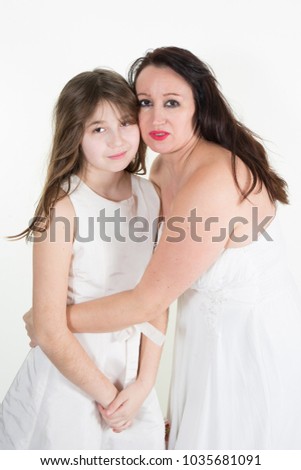 mother with little cute daughter in white dress posing on white