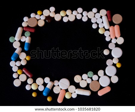 Frame of pills on a dark background with free space for text, top view.