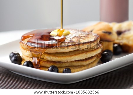 Close up of pouring maple syrup on hotcakes Pancake Breakfast Yumm butter melting Royalty-Free Stock Photo #1035682366