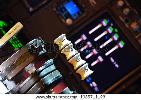 Close up of the throttle controls and instrument gauges in the cockpit of an airplane