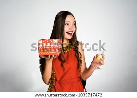 happy woman holding a glass of champagne and a gift in her hand