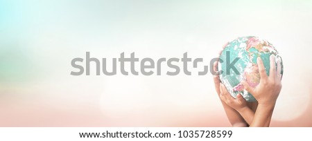 World environment day concept: Many human hands holding earth globe over blurred nature background. Elements of this image furnished by NASA
