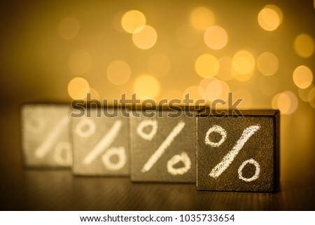 Percent signs chalk written on  black cubes on blurred bokeh background