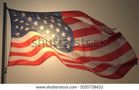 the USA flag on pole with sun flare transparent view from bottom