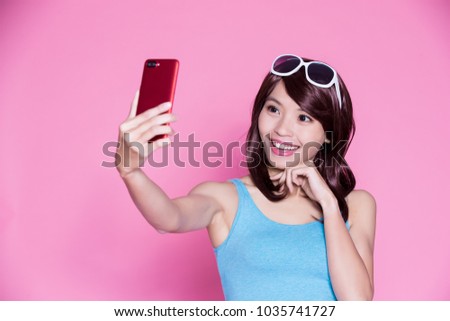 woman wear sunglasses and selfie happily on the pink background