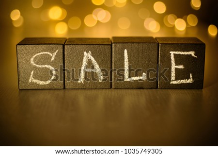 Sale word chalk written on black cubes on blurred bokeh background