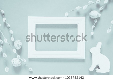 Easter eggs, pussy-willow  branches, rabbit, wooden frame, soft and light Easter background, pastel colors, toned photos. Flat lay, top view, copy space