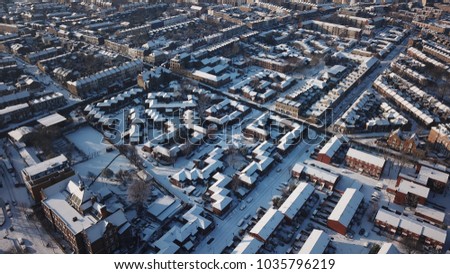 Aerial Drone Image of snowy residential rooftops in South London (Battersea) on a sunny day.