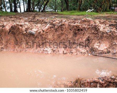 The image of muddy roads, deep tracks of car wheels, and stagnant water in mud hole after the rain.