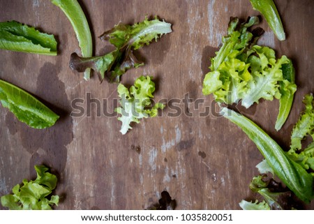 Green salad on the wooden table as a background. Green vegetable a day make good health benefits. Vegetables in salads are good sources of fiber.