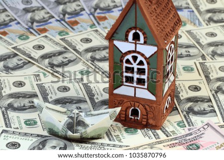 the house stands on a pile of American hundred-dollar bills as a symbol of prosperity