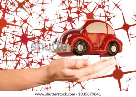Red toy car model above woman hand on a white background with red stars shape.
