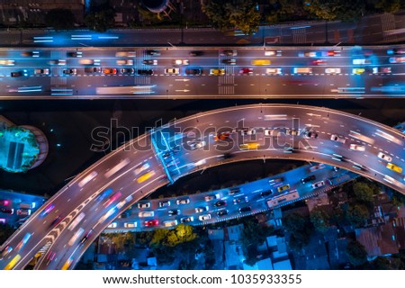 Rush hour traffic on a city roads. Modern metropolis with intersection of the traffic trails on a highway. Traffic jams of roadside, transportation motion in a big city. Royalty-Free Stock Photo #1035933355