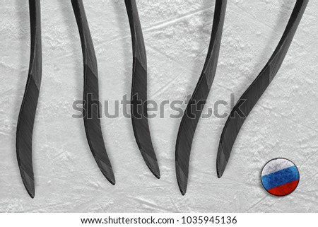 Russian puck and five sticks on the ice of the hockey arena. Concept, hockey