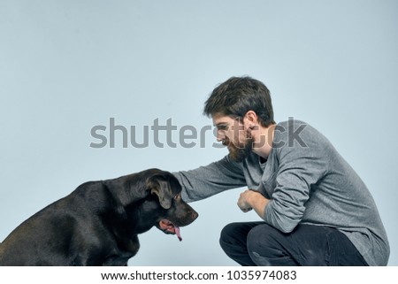 a man is stroking a labrador on a blue background                               