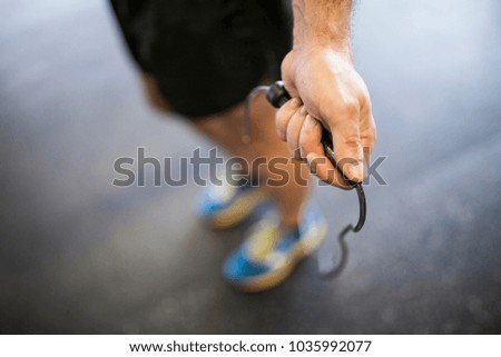 close-up of man's hand near the cage jumping rope