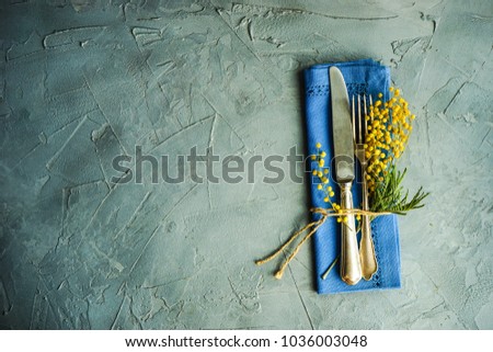 Spring table setting with bright yellow mimosa flowers