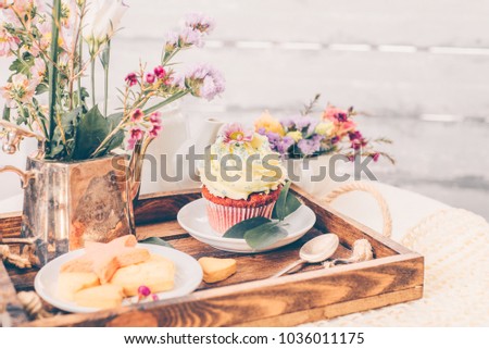 Cakes on beautiful wooden tray with flowers, spring mood still life photo for holiday design