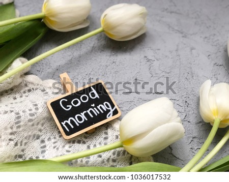good morning chalkboard with white tulips on grey background