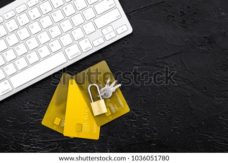 Secure payments. Bank cards near lock and keys and keyboard of computer on black background top view copy space