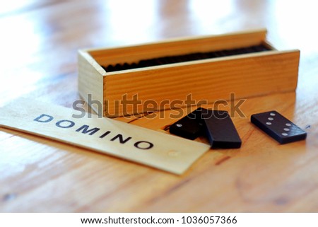 plastic domino game with wooden box set on wooden background 
