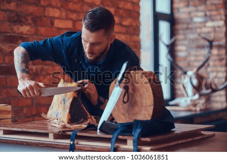 Professional butcher is cutting raw smoked meat on a table for c