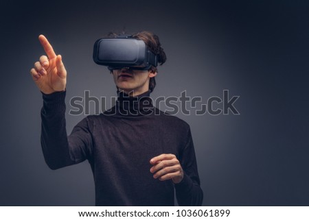 Portrait of a man wearing virtual reality device isolated on a d