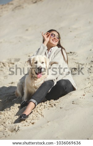 Pretty young woman outdoors with dog. Golden retriever and his owner resting