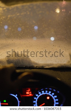 Person drives vehicle on snow covered roads at night. 