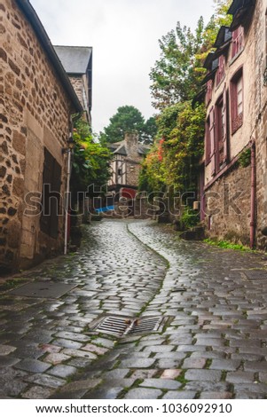 Pedestrian medieval cobbled road leading upward to traditional half-timbered houses in old town of Dinan, Brittany, France