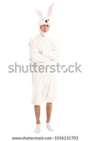 Rabbit man in a white costume in a serious pose with hands crossed.