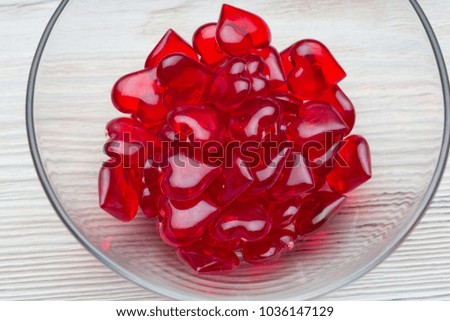Love for Valentine's day: red beads with a shape of a heart on wood plank floor