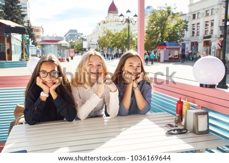 young women girlfriends sitting at a cafe table