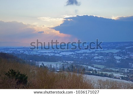 Looking towards a snow covered Stroud Valley, at sunset, from Juniper Hill, a Site of Special Scientific Interest, this is in the Cotswold Area of Outstanding Natural Beauty, Gloucestershire, UK