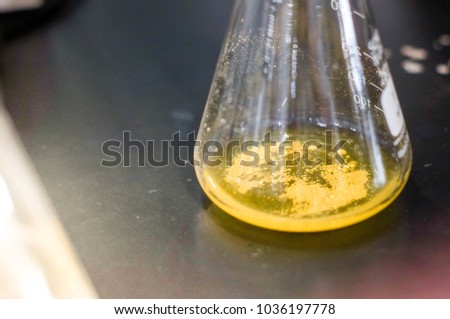 white precipitate in yellow solution Royalty-Free Stock Photo #1036197778