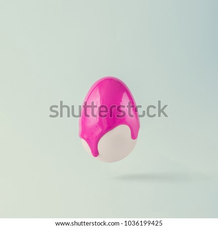 Easter egg with punchy pink paint dripping. Minimal concept. Royalty-Free Stock Photo #1036199425