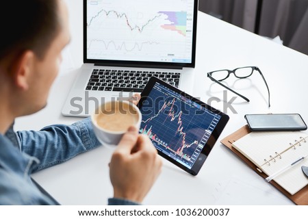 Investor watching the change of stock market on tablet. Royalty-Free Stock Photo #1036200037