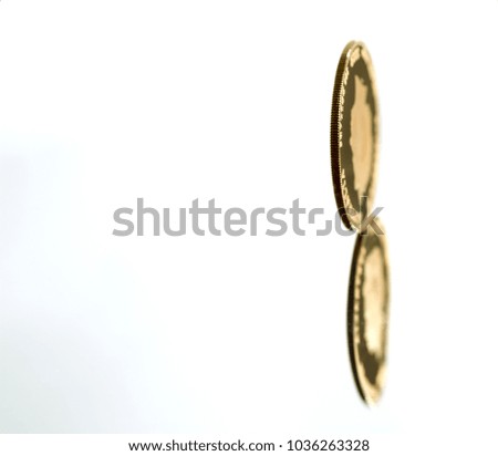 Rolling gold coin with reflection isolated on white background. Selective focus.  