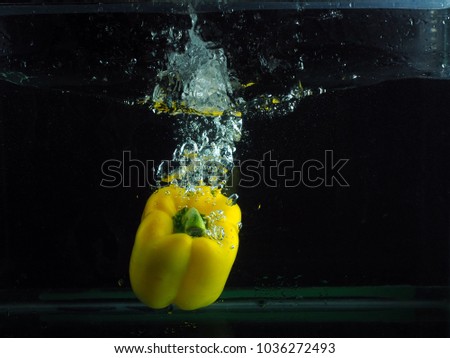 Yellow Bell Pepper Water Splash In Black Background 